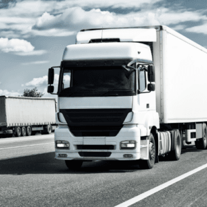 Camion blanc roulant sur une autoroute, symbole du transport durable utilisant le biodiesel HVO 100 (hvodiesel) pour réduire les émissions de CO2 en Wallonie.
