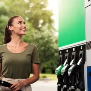 Femme souriante à une pompe à carburant, représentant les avantages du biodiesel HVO100 et du HVOdiesel comme alternative écologique et économique.